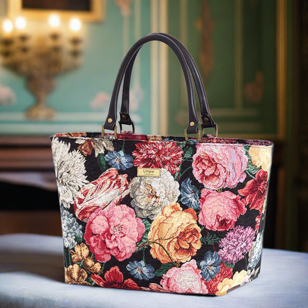 The Floral Tapestry Handbag with black leather handles.
