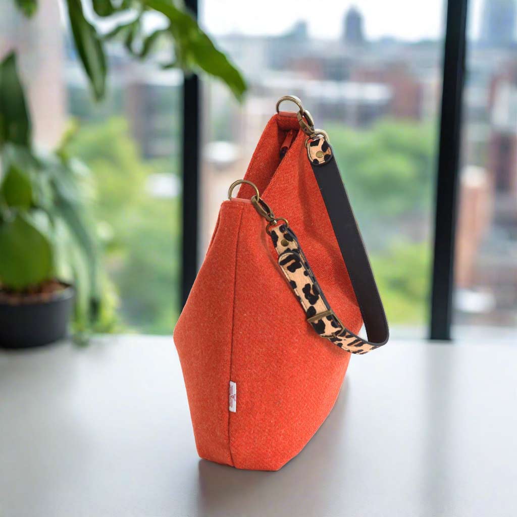 The Orange Harris Tweed Hobo Bag with a leopard print leather strap - top-zip view
