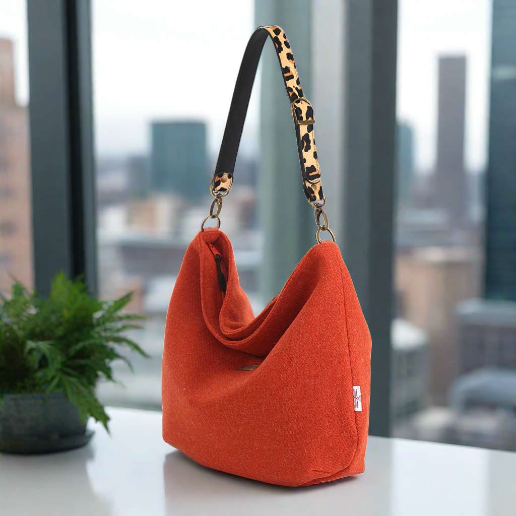 The Orange Harris Tweed Hobo Bag with a leopard print leather strap