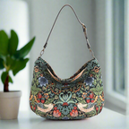 Luxurious hobo bag featuring William Morris's iconic Strawberry Thief pattern in rich indigo blue with delicate birds and strawberry motifs, crafted with premium fabric and leather trim, front view showcasing the elegant curved silhouette by Umpie Handbags