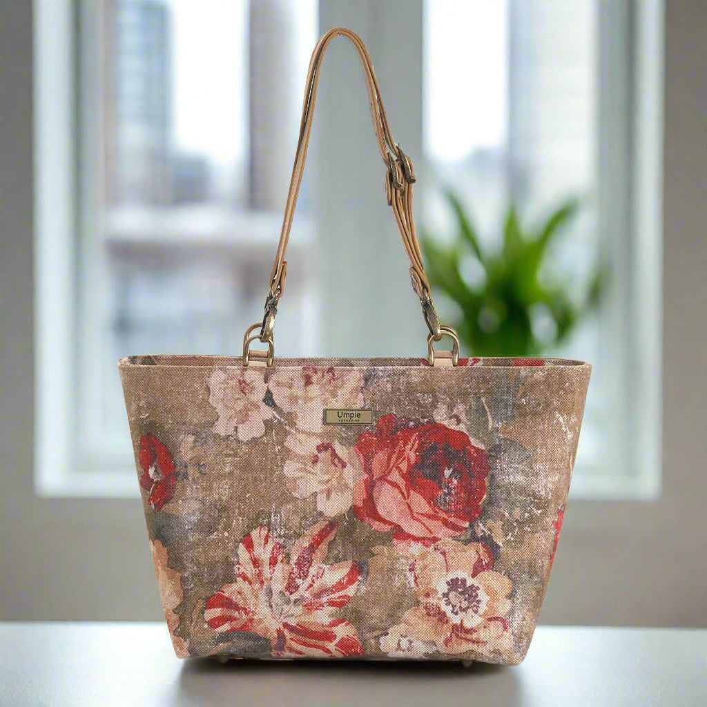 A shoulder bag in beige and red antique-style floral fabric with matching leather shoulder straps