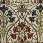 Close-up of Art Nouveau tapestry fabric on the Umpie Crossbody Bag — richly woven cream ground with deep burgundy irises, navy florals, and sage stems, with Umpie Yorkshire brand badge, by Umpie Handbags