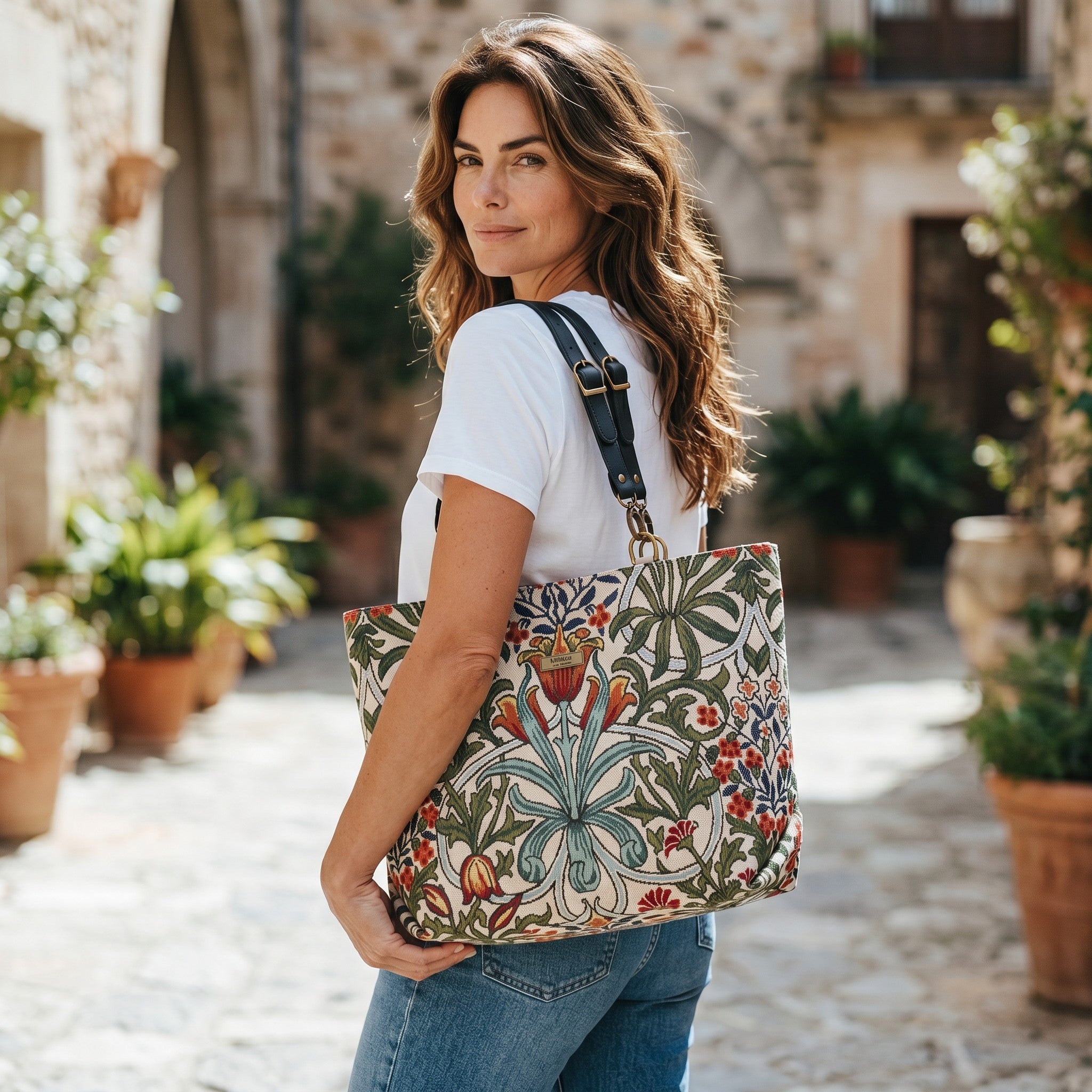 William Morris Arts & Crafts botanical tapestry tote bag worn over the shoulder, rich floral pattern with black leather straps, handcrafted in Yorkshire by Umpie Handbags