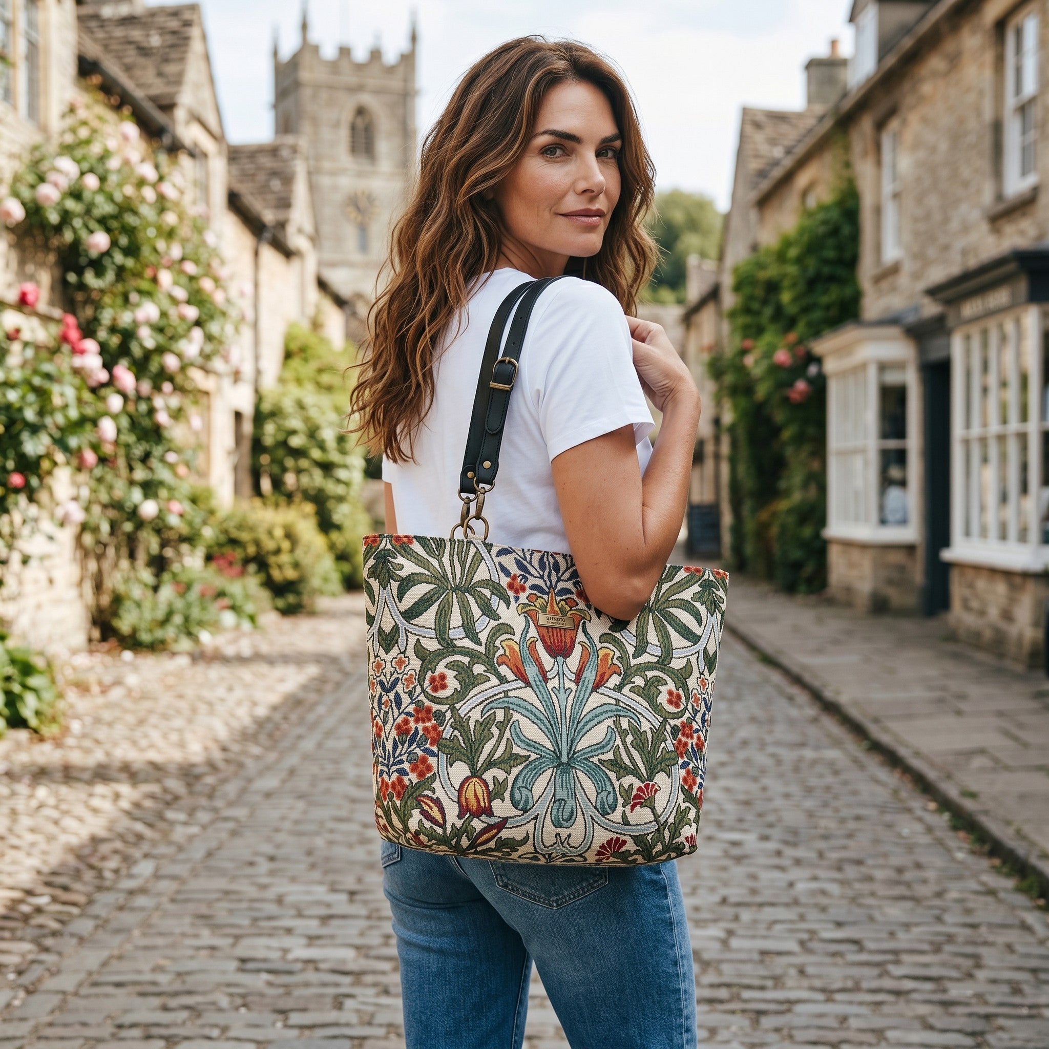 Arts & Crafts botanical tapestry tote bag worn over the shoulder, rich floral pattern with black leather straps, handcrafted in Yorkshire by Umpie Handbags