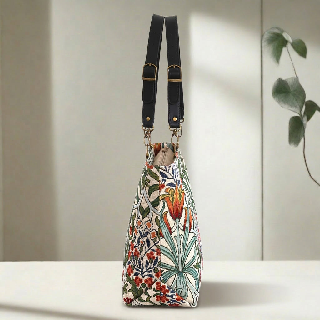 Angled side view of William Morris Arts & Crafts tote bag showing structured silhouette and depth, botanical tapestry fabric with black leather handles, by Umpie Handbags
