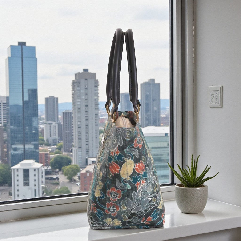Side profile of Batik handbag revealing structured shape, black leather handles, and distinctive geometric form by Umpie Handbags