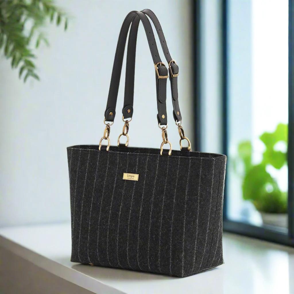 Savile Row-inspired pinstripe wool shoulder bag with premium black leather straps and antique hardware - handcrafted British luxury handbag