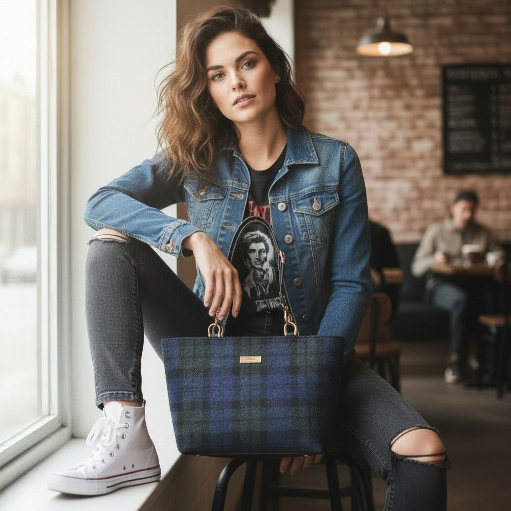 Black Watch tartan Harris Tweed shoulder bag with bold contrast black leather straps, styled with confident attitude pose showcasing structured silhouette and rebellious Scottish heritage design by Umpie Handbags