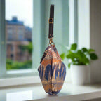 Bronze metallic hobo bag side profile showing spacious design and adjustable leather strap