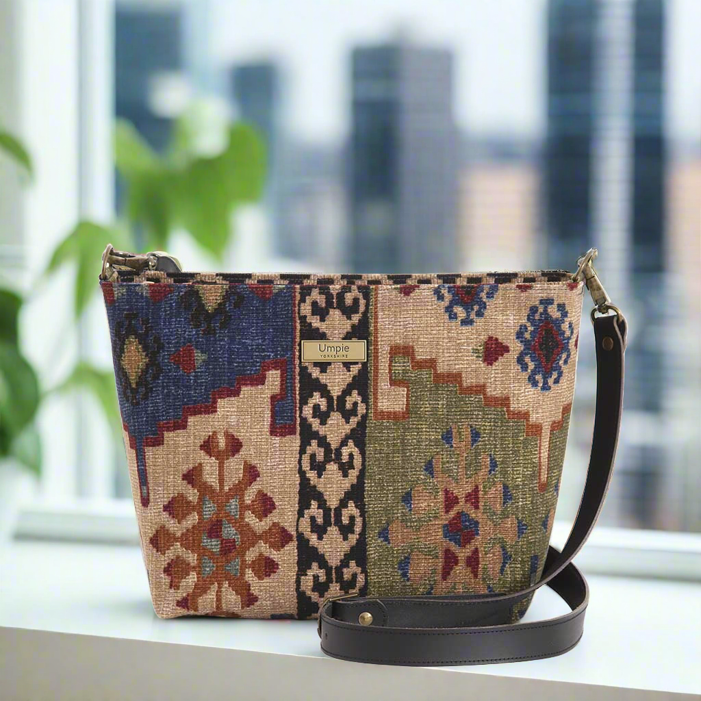 The Canvas Crossbody Bag in a kilim design with a black leather strap