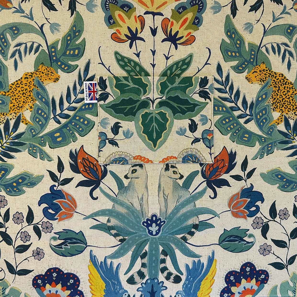 Decorative fabric pattern lining with leopards, butterflies, and floral elements on a beige background.