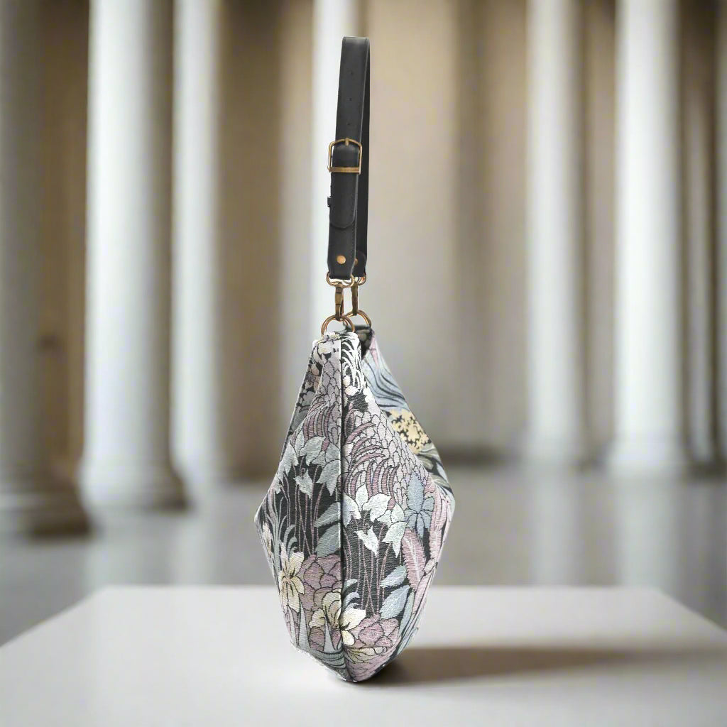 The Grey Floral Hobo Bag with a black leather strap, side view