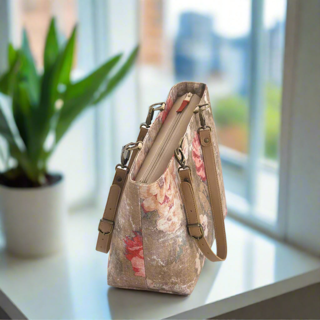 The top zip view of a shoulder bag in a beige and red antique-style floral fabric with matching leather straps