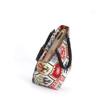 Zip-top view of the Hexagon Handbag revealing the structured trapezoid shape with the kilim-inspired tapestry body and black leather handles with antique brass fittings visible, handmade in Yorkshire by Umpie Handbags

