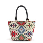 Hexagon Handbag in multicoloured kilim-inspired tapestry fabric with geometric hexagon panels, black leather top handles and antique brass hardware, handmade in Yorkshire by Umpie Handbags