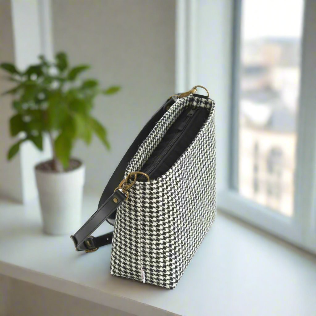 The Houndstooth Crossbody Bag with a black leather strap - zip-top view