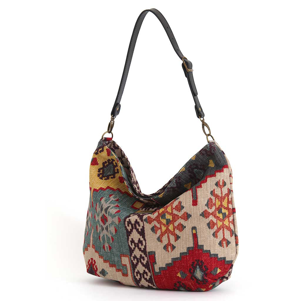 Kilim Canvas Hobo Bag worn over the shoulder showing red mix geometric patterns and relaxed silhouette by Umpie Handbags