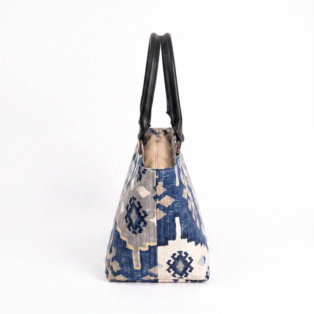 Navy canvas handbag with traditional Kilim geometric pattern in navy, grey, light blue and taupe, black leather handles, side view by Umpie Handbags