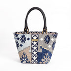 Navy canvas handbag with traditional Kilim geometric pattern in navy, grey, light blue and taupe, black leather handles, front view by Umpie Handbags