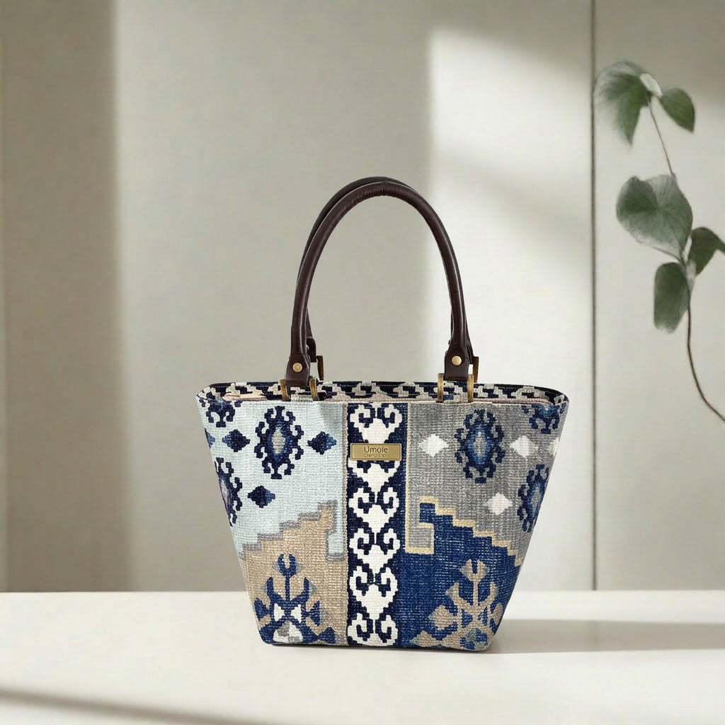 Navy canvas handbag with traditional Kilim geometric pattern in navy, grey, light blue and taupe, brown leather handles, front view by Umpie Handbags