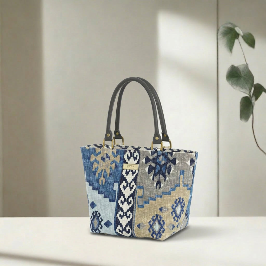 Navy canvas handbag with traditional Kilim geometric pattern in navy, grey, light blue and taupe, brown leather handles, front view by Umpie Handbags
