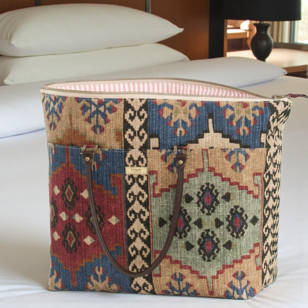 The Canvas Weekend Bag, Kilim Design. Showcasing multicoloured, authentic kilim print with brown leather handles. Handcrafted in Yorkshire by Umpie Handbags