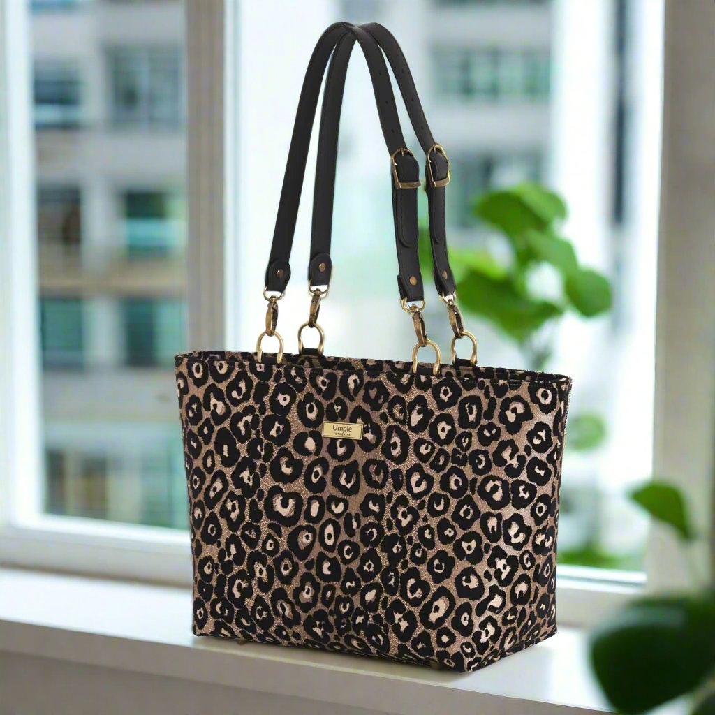 Leopard print shoulder bag with black leather straps