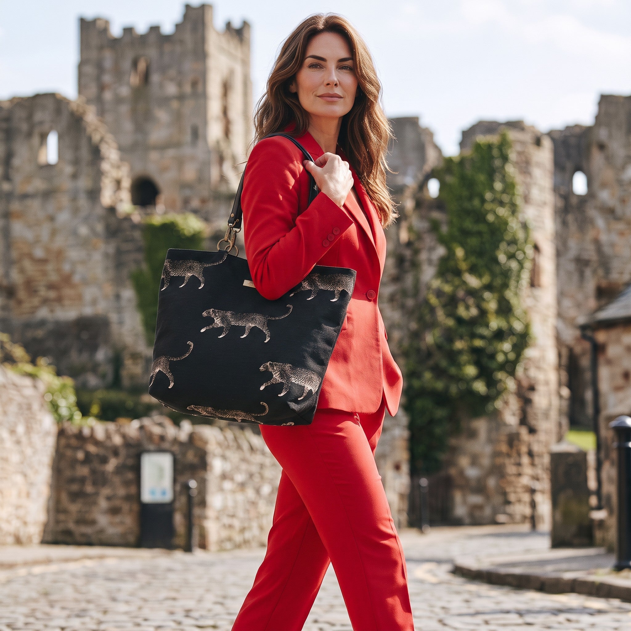 Model carrying luxurious black embroidered tapestry leopard tote bag featuring bold animal print pattern and premium black leather straps, showcasing spacious silhouette and comfortable shoulder carry for everyday style by Umpie Handbags