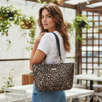 Model wearing luxurious metallic leopard print shoulder bag with bold spotted pattern in rich bronze and black tones, premium black leather straps draped over shoulder by Umpie Handbags