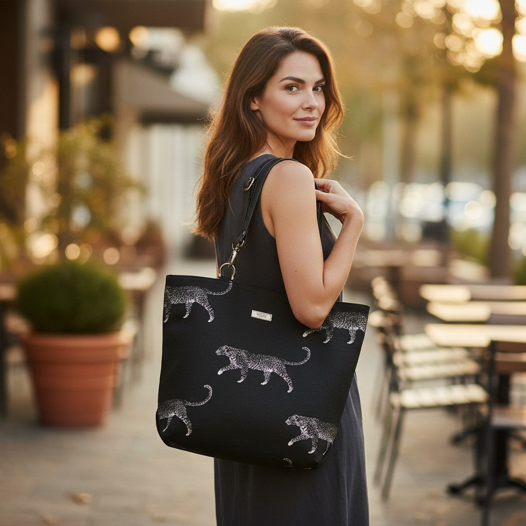 Model carrying luxurious black embroidered tapestry leopard tote bag featuring bold animal print pattern and premium black leather straps, showcasing spacious silhouette and comfortable shoulder carry for everyday style by Umpie Handbags