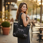 Model carrying luxurious black embroidered tapestry leopard tote bag featuring bold animal print pattern and premium black leather straps, showcasing spacious silhouette and comfortable shoulder carry for everyday style by Umpie Handbags