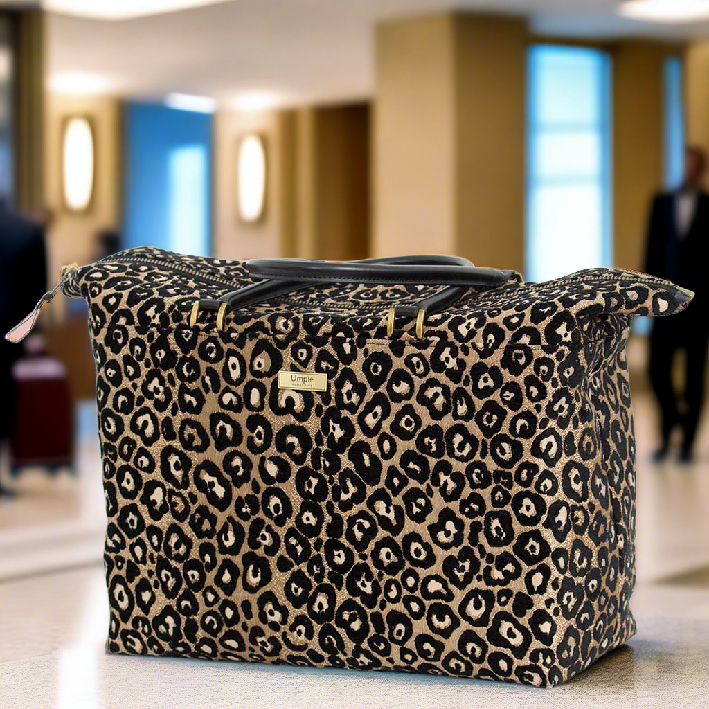 The Leopard Weekend Bag with black leather handles.