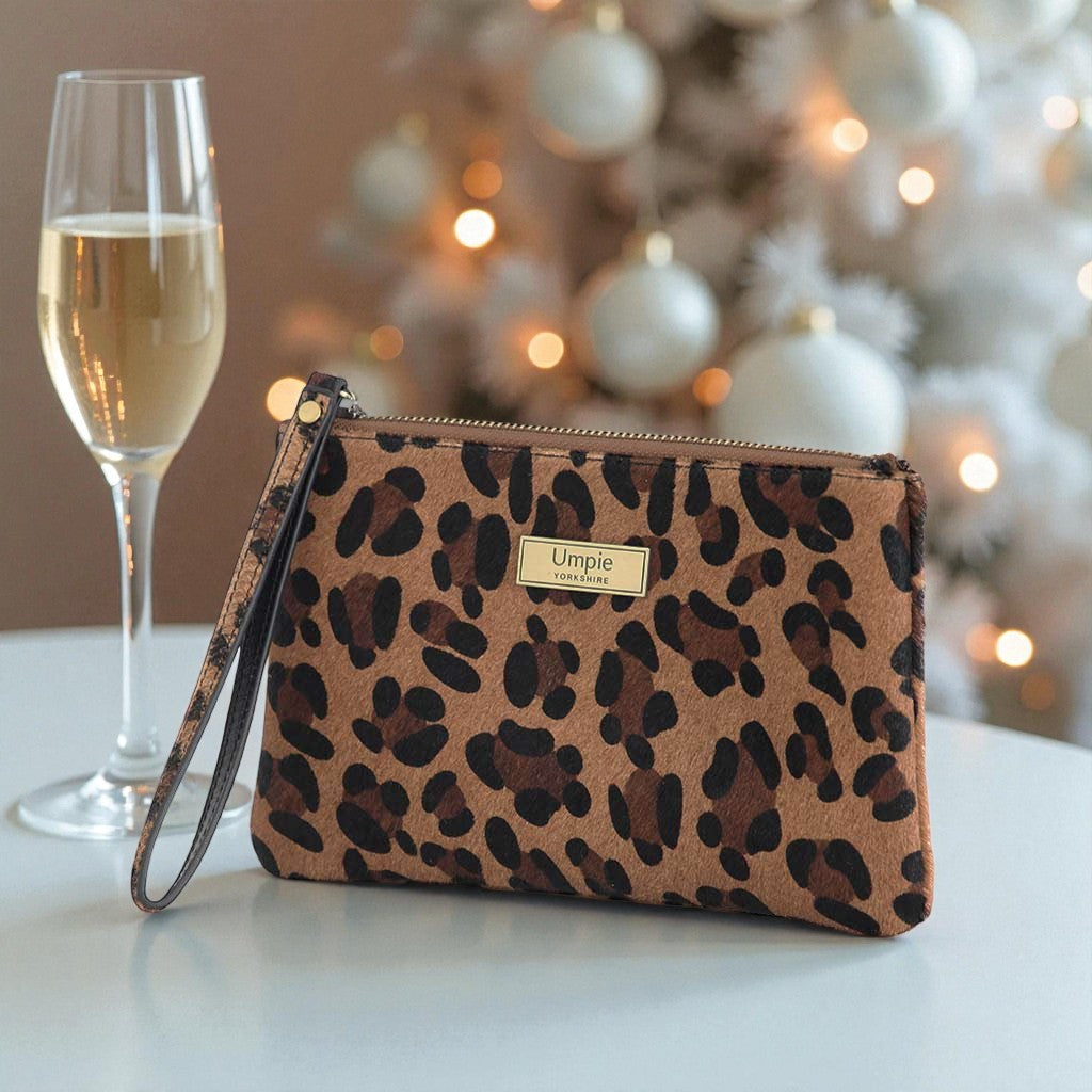 Luxurious hair on leather leopard print clutch bag with gold-tone wrist strap and premium hardware, front view showcasing exotic natural pattern by Umpie Handbags