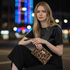 Hair on Leather Leopard Clutch Bag held by model in evening setting showing authentic leopard print and wrist strap by Umpie Handbags
