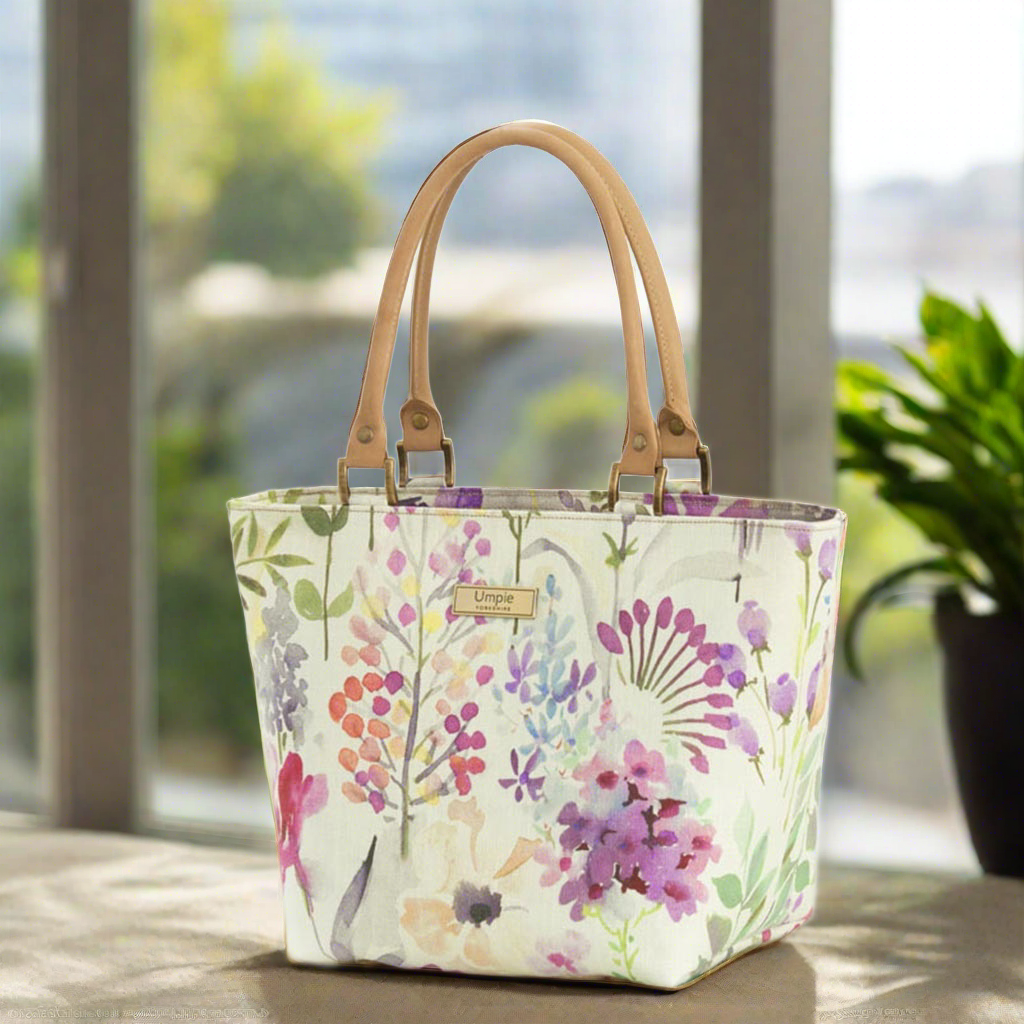 The Lilac Handbag with light tan leather handles.
