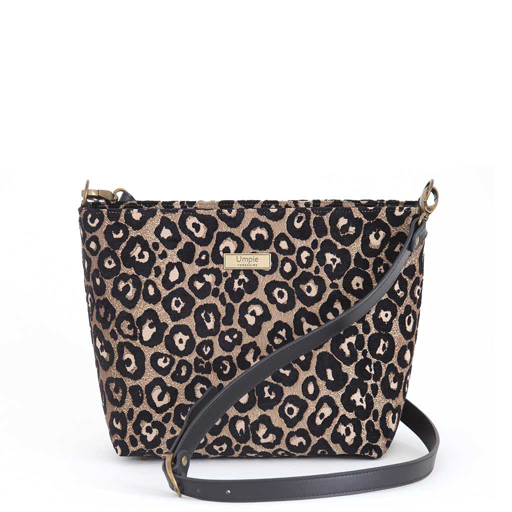 Compact leopard print crossbody bag displayed at an angle, showcasing the eye-catching metallic sheen and structured silhouette with premium black leather strap by Umpie Handbags