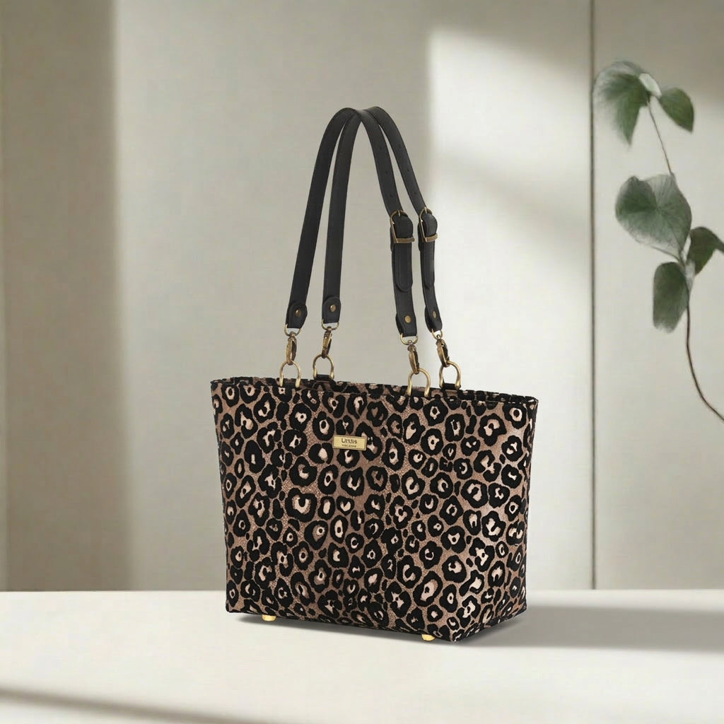 Leopard print shoulder bag displayed at an angle, highlighting the eye-catching metallic sheen, generous proportions, and quality black leather strap detailing by Umpie Handbags
