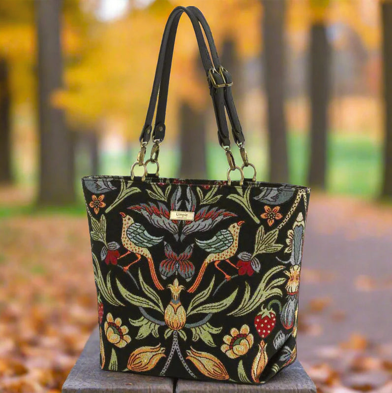 The William Morris Shoulder Bag seated on a wooden bench in autumn leaves by Umpie Handbags