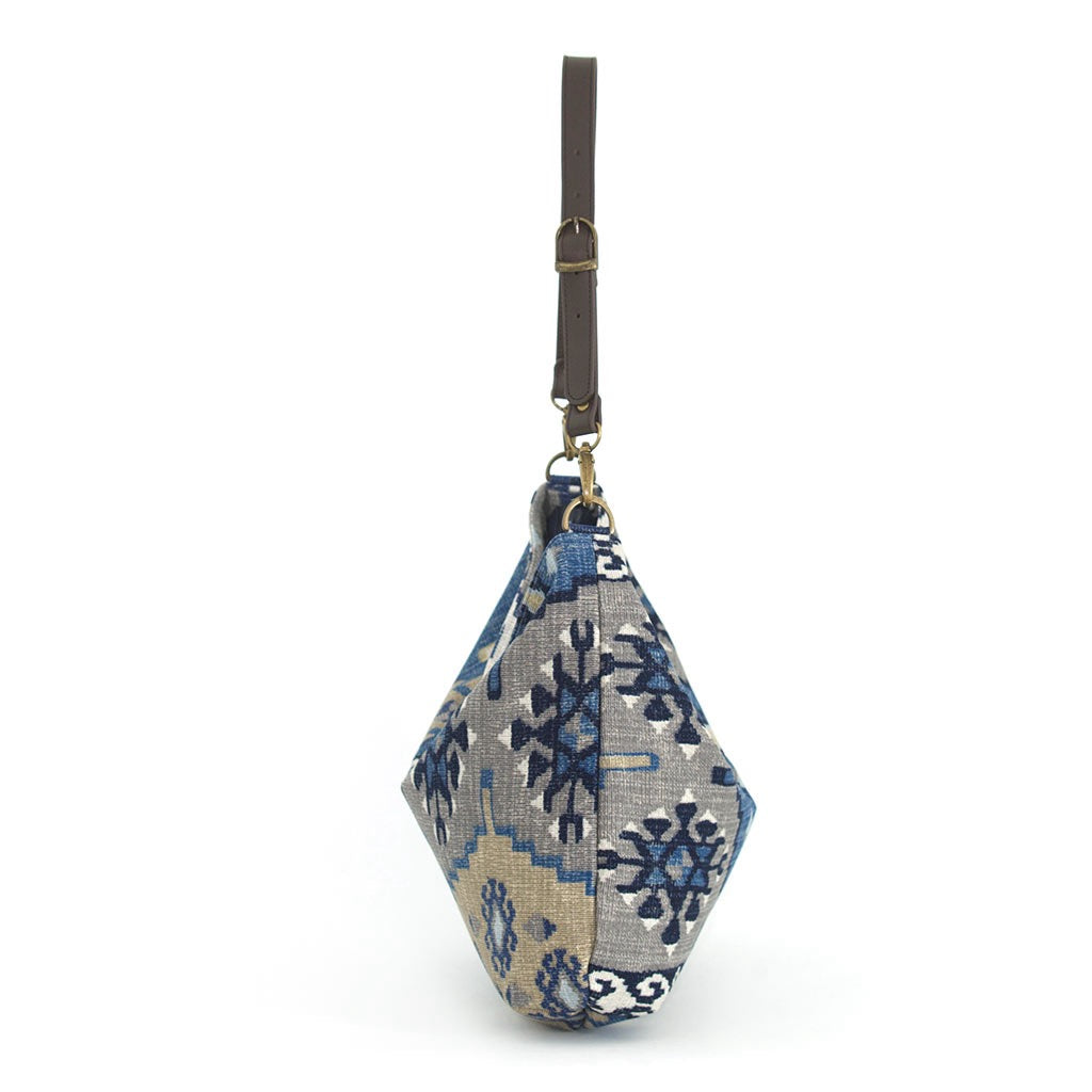 The side view of the Artisan Navy Kilim Canvas Hobo Bag with a brown leather strap by Umpie Handbags