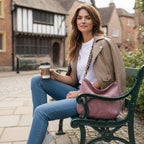A woman seated on a bench holding the Pink Velvet Hobo Bag with a Leopard print strap by Umpie Handbags