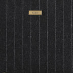 Close-up of premium British wool pinstripe fabric with Savile Row-inspired perfectly aligned pattern - traditional tailoring meets luxury handbag design

