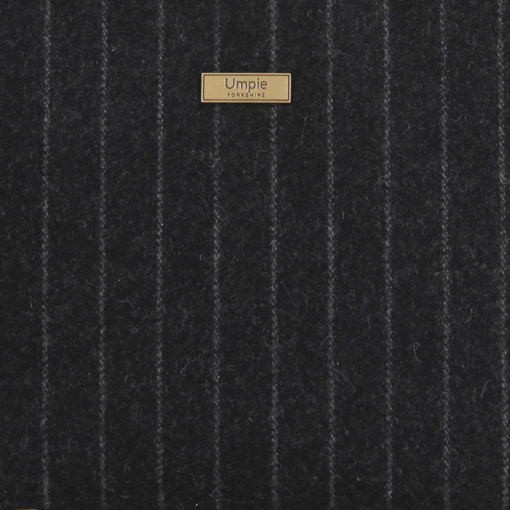 Close-up of premium British wool pinstripe fabric with Savile Row-inspired perfectly aligned pattern - traditional tailoring meets luxury handbag design

