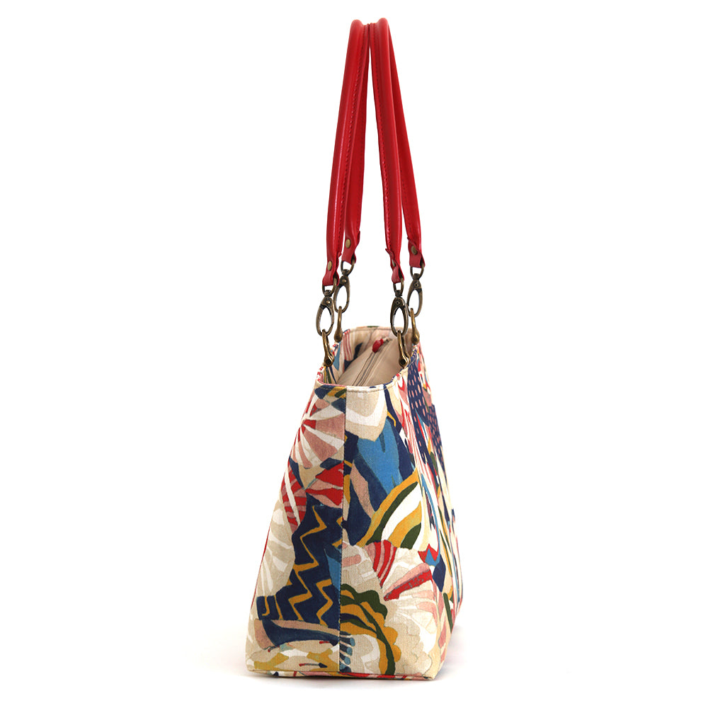 The side view of the red floral shoulder bag with red leather handles, handmade in Yorkshire by Umpie Handbags.