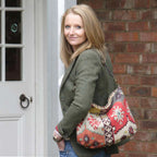 A woman wearing the Red Mix colour, Kilim Design Canvas Hobo Bag With Black Leather Strap by Umpie Handbags