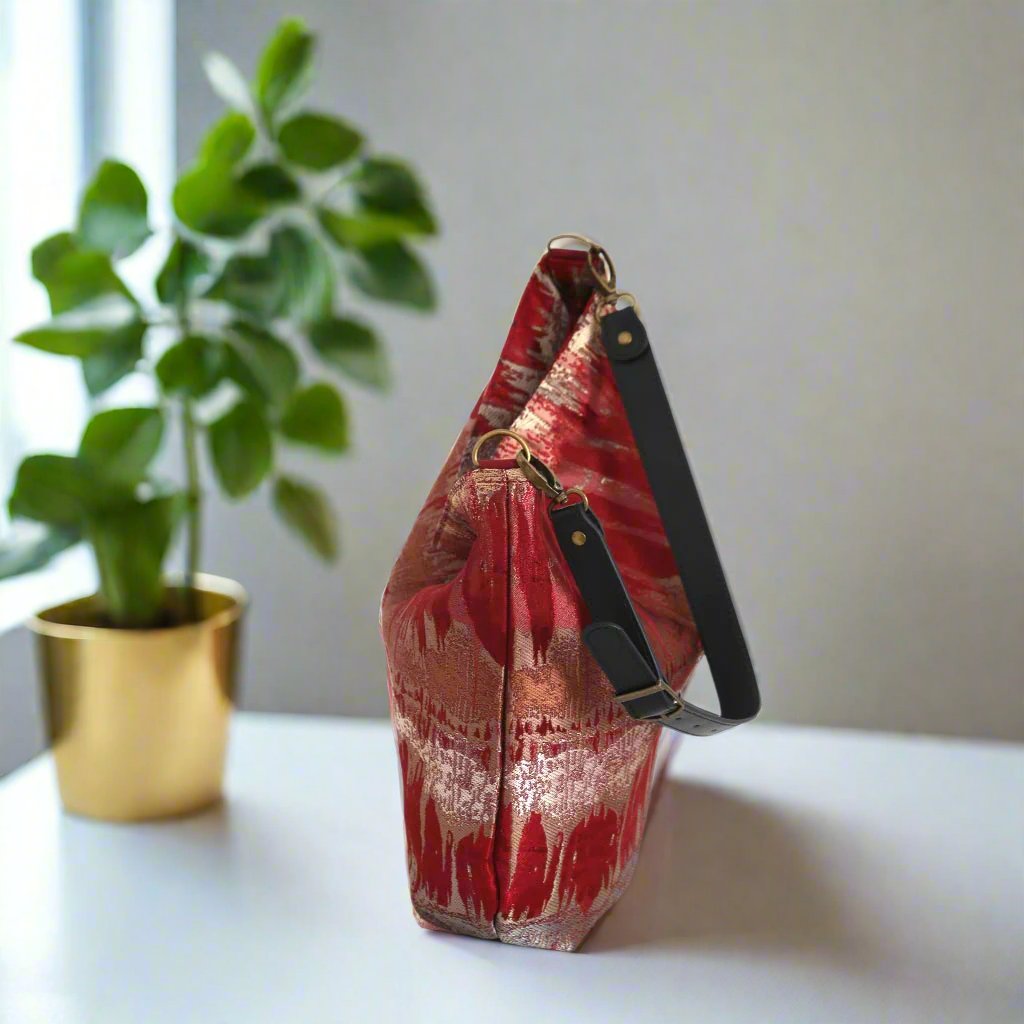 The Red Metallic Hobo Bag with a black leather strap - zip-top view