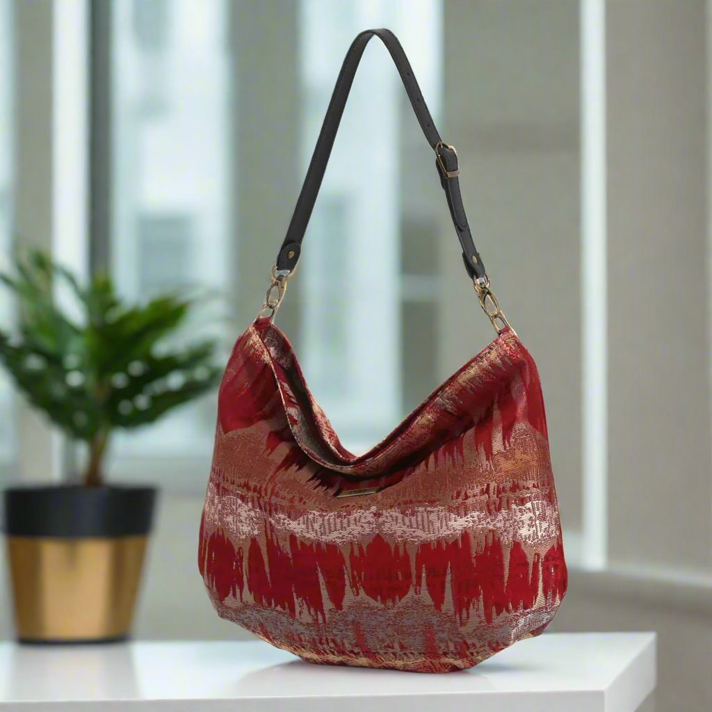 The Red Metallic Hobo Bag with a black leather strap.