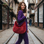 Model wearing the red velvet hobo bag with leopard print leather strap and antique gold hardware, styled with a purple suit — by Umpie Handbags