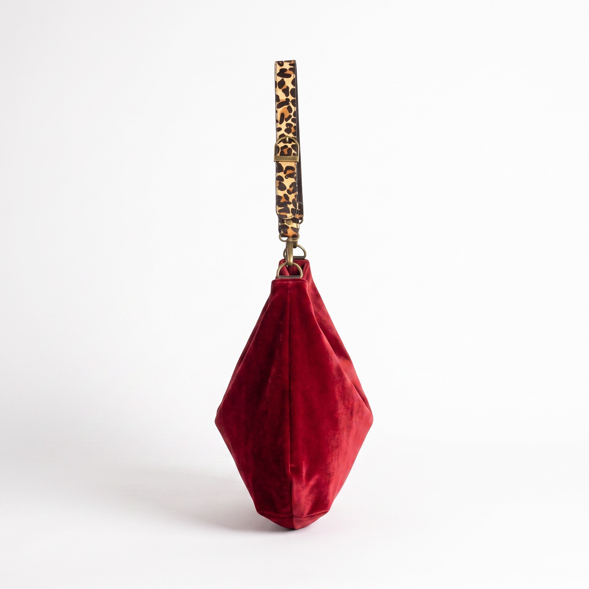 Side view of the red velvet hobo bag showing the generous slouchy silhouette and leopard print strap by Umpie Handbags