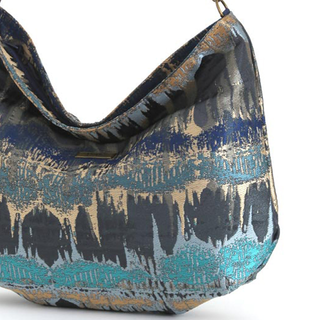 Close up view of Teal Metallic Hobo Bag worn on shoulder showing shimmering brocade fabric and vibrant teal colour by Umpie Handbags