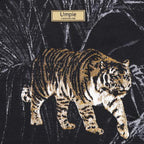 Close-up of vibrant tiger-print tapestry fabric featuring bold gold, black and cream tones with intricate woven texture and artisan craftsmanship by Umpie Handbags